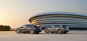 Rear view of two Audi vehicles parked in front of an Audi dealership at dusk