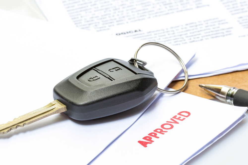 Car key on top of an approved loan document