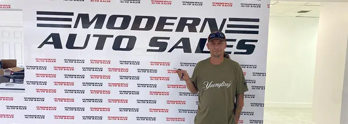 Happy customer holding keys after purchasing a vehicle at Modern Auto Sales in Hollywood, FL.